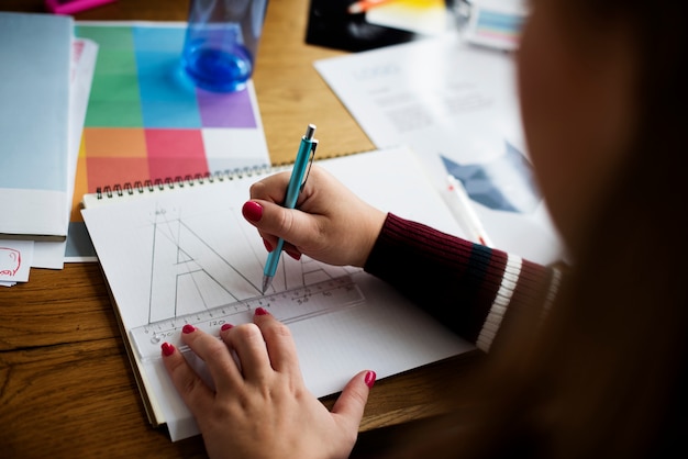 Free photo caucasian female hands illustrating in a notebook