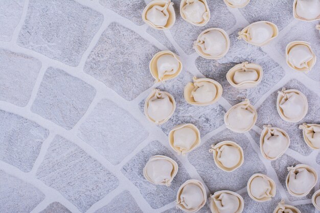 Caucasian khinkali dough in flour on grey surface