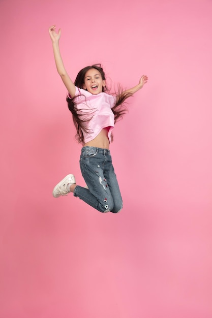 Caucasian little girl portrait isolated on pink studio, emotions concept