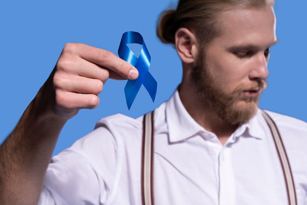 Free Photo caucasian man holding a blue ribbon