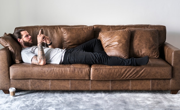 Free photo caucasian man listening to music on a couch