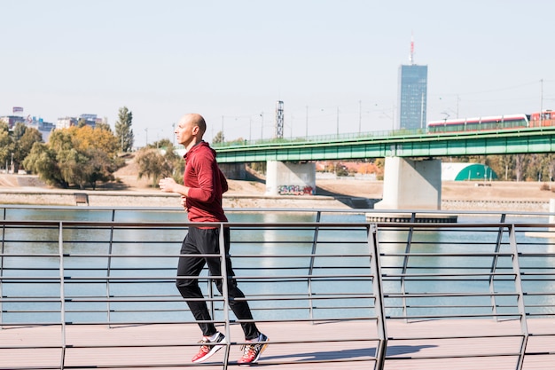 Caucasian man runner running near the river