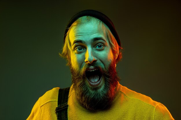 Caucasian man's portrait isolated on gradient studio background in neon light