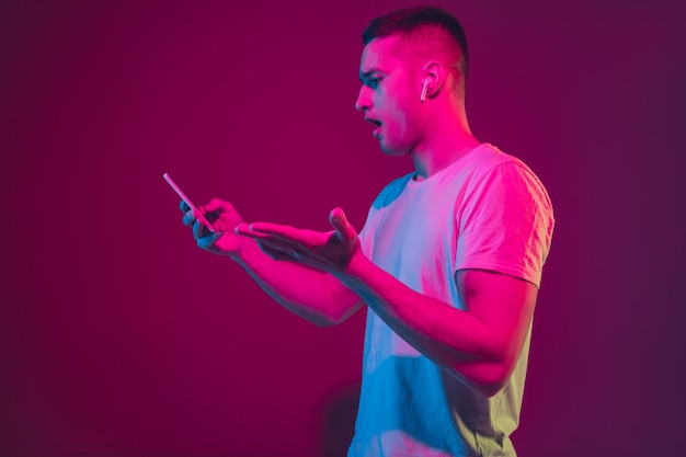 Caucasian man's portrait isolated on pink-purple studio wall.