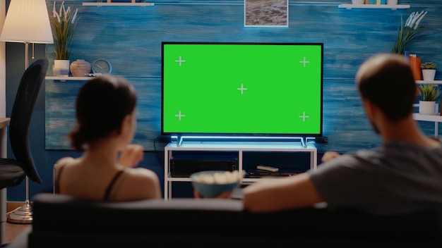 Free photo caucasian people enjoying green screen layout on tv