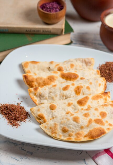 Caucasian qutab, kutab, gozleme served with sumakh, herbs and yogurt.