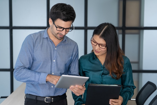 Caucasian supervisor helping new Asian employee. 