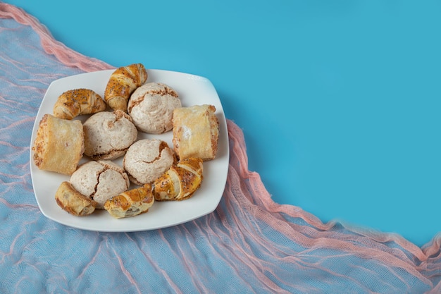 Caucasian traditional cookies with sugar powder on top on white ceramic plate.