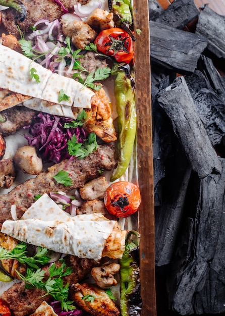 Caucasian traditional Kebab platter with grilled foods and herbs.