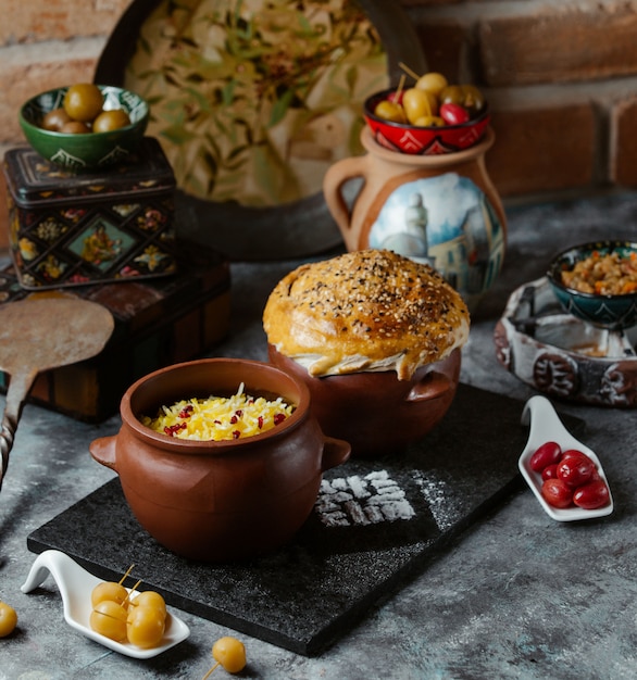 Caucasian traditional rice garnish with herbs inside a pottery bowl served with bread bun