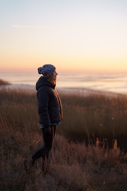 Caucasian woman enjoying nature view outdoors in the evening watching sunset