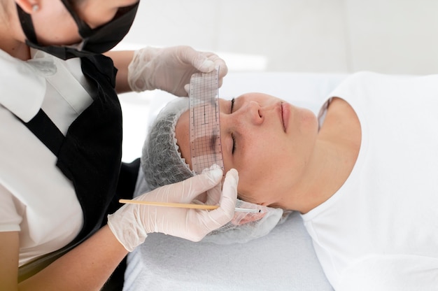 Free photo caucasian woman going through a microblading procedure