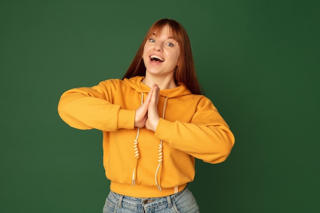 Caucasian woman's portrait isolated on green studio background with copyspace