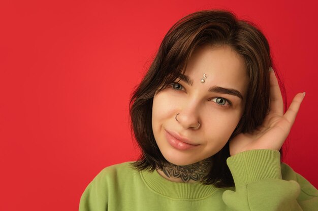 Caucasian woman's portrait isolated on red studio background with copyspace