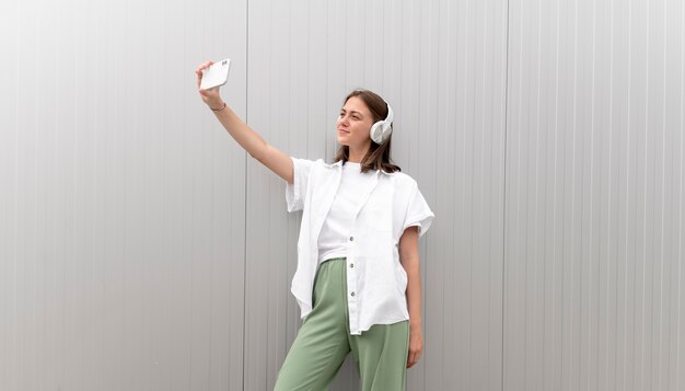 Caucasian woman taking a selfie with her smartphone