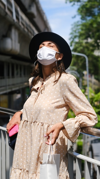 Free Photo caucasian woman walking on subway crossing in medical face mask while pandemia in bangkok city.