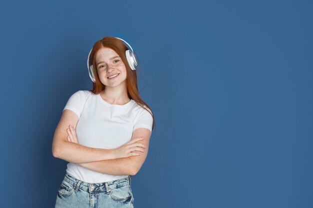 Caucasian young girl's portrait isolated on blue studio