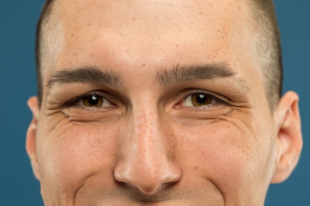 Caucasian young man's close up shot on blue studio