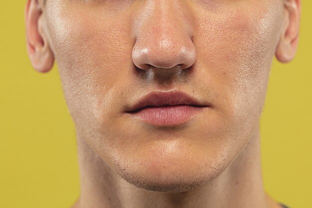 Caucasian young man's close up on yellow studio