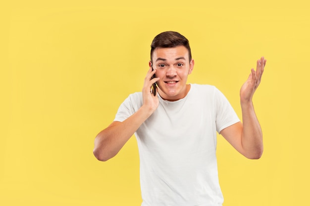 Caucasian young man's half-length portrait on yellow wall