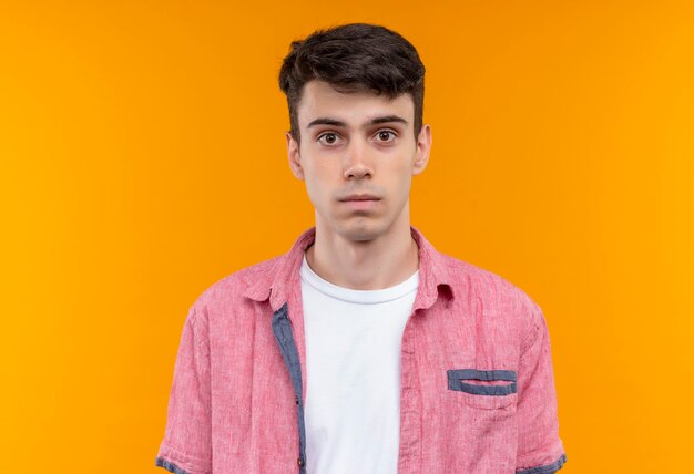 caucasian young man wearing pink shirt on isolated orange wall