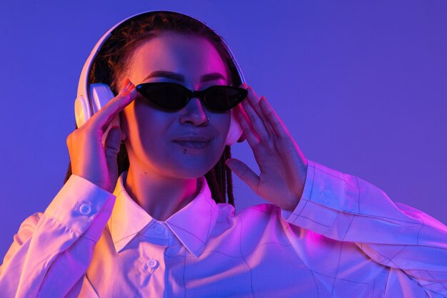 Caucasian young woman's portrait on dark studio background in neon Concept of human emotions facial expression