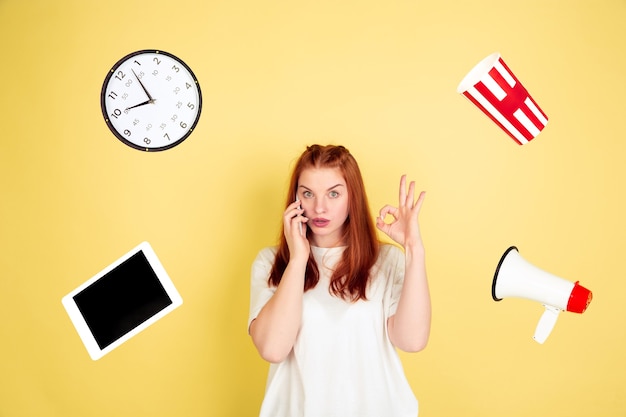 Caucasian young woman's portrait on yellow background, too much tasks