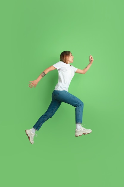 Caucasian young womans portrait on green studio wall