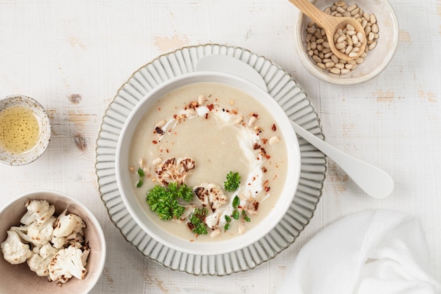 Free Photo cauliflower cream soup with pine nuts in a bowl on a white background