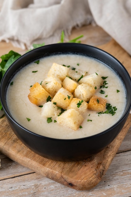 Free photo cauliflower soup in a bowl on wooden table