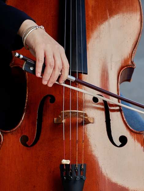 Free Photo cellist player hands. violoncellist playing cello on background of field. musical art, concept passion in music. classical music professional cello player solo perform