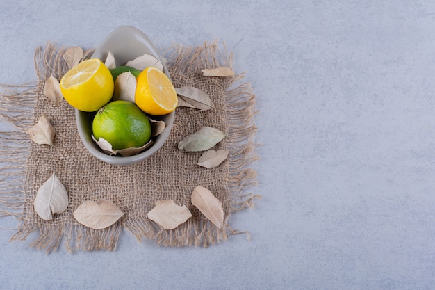 Free photo ceramic bowl of fresh juicy lemons on stone table.