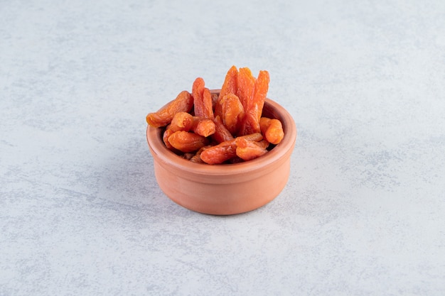 Free photo ceramic bowl with delicious dried fruits on stone background.