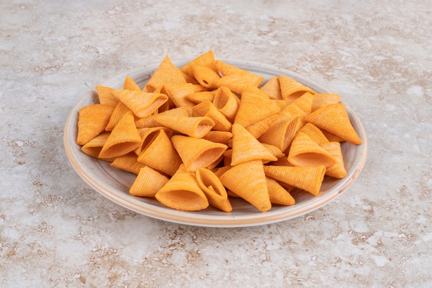 Ceramic plate of crunchy triangle chips on marble.