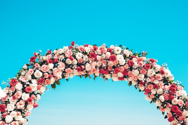 Free photo ceremonial wedding arch on the beach decorated with natural flowers