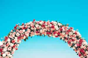 Free photo ceremonial wedding arch on the beach decorated with natural flowers