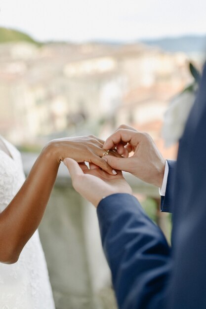 Ceremony of putting the wedding ring on the bride's finger outdoors