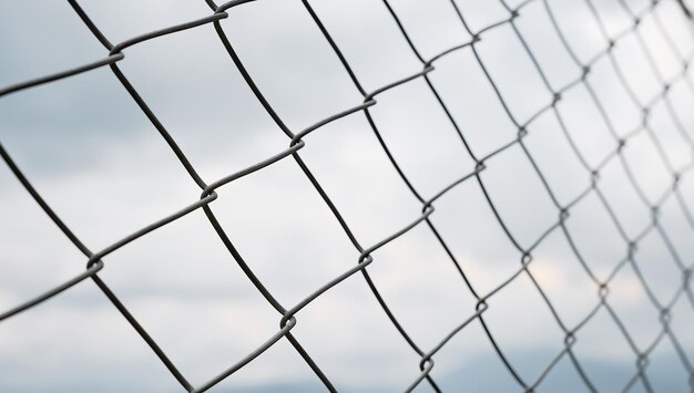 Chain fence closeup against a cloudy sky protection from intrusion and restriction of freedom selective focus