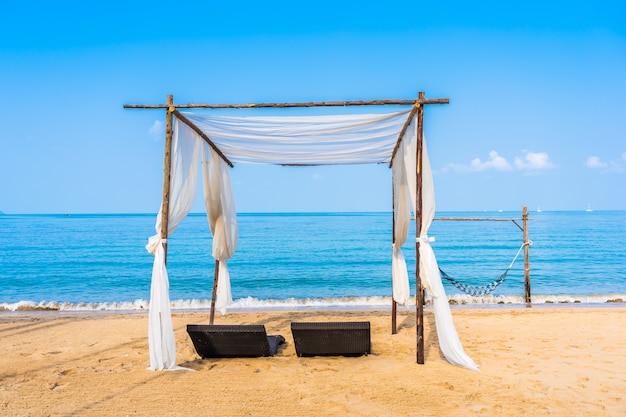 Free photo chair umbrella and lounge on the beautiful beach sea ocean on sky