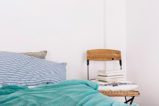 Chair with pillow and books near bed