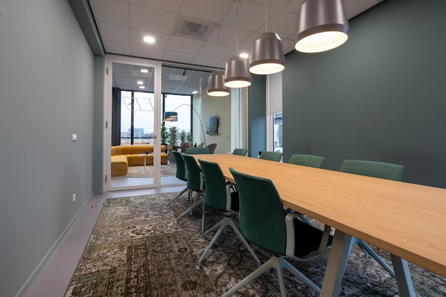 Free Photo chairs put next to a table in a room with a patterned carpet