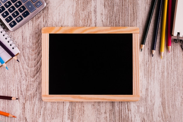 Free photo chalk board and stationery on wooden surface