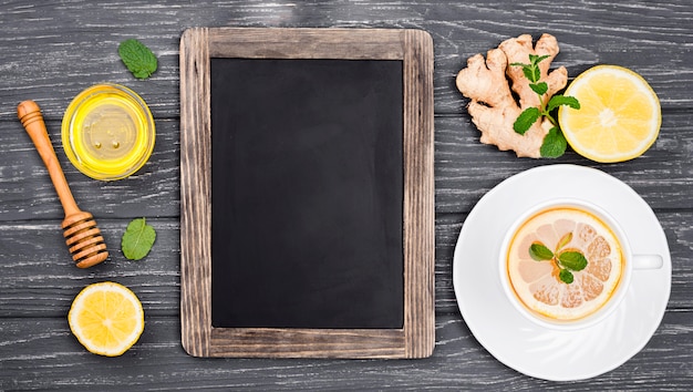 Chalkboard beside cup with lemon tea and honey