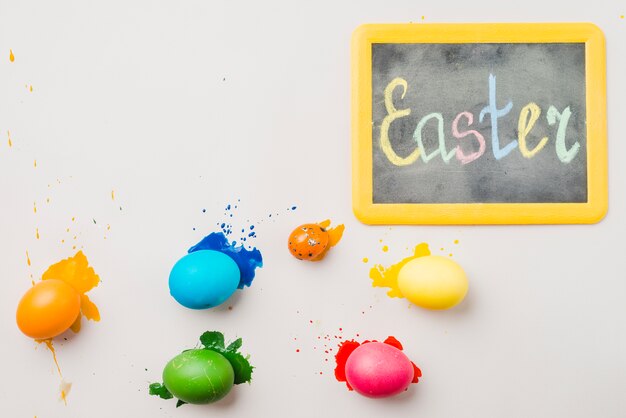 Free photo chalkboard with easter title near collection of colored eggs