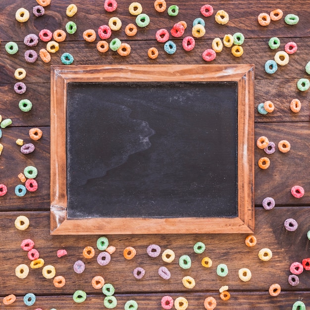 Chalkboard with scattered cereals on table 