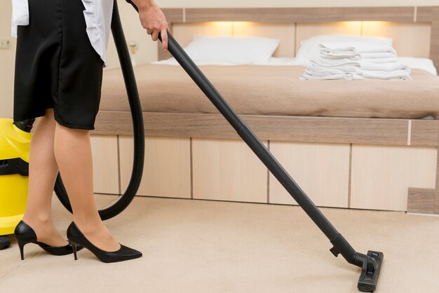 Chambermaid cleaning hotel room