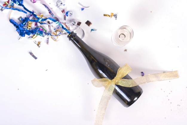 Free photo champagne bottle decorated with confetti and ribbon