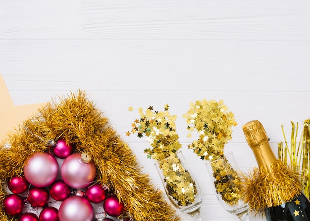 Free photo champagne bottle with shiny baubles on table