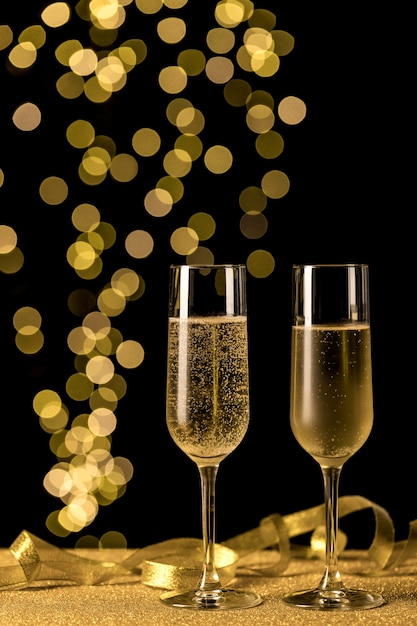 Free photo champagne glasses with bokeh lights