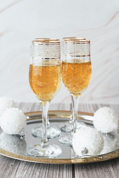 Free Photo champagne glasses with christmas balls on a tray